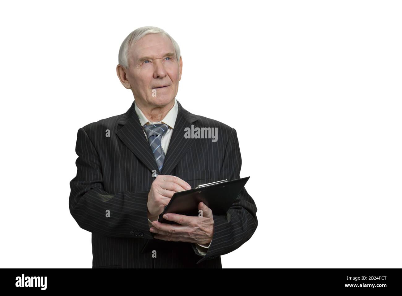 Senior businessman looks up and writing down. Stock Photo