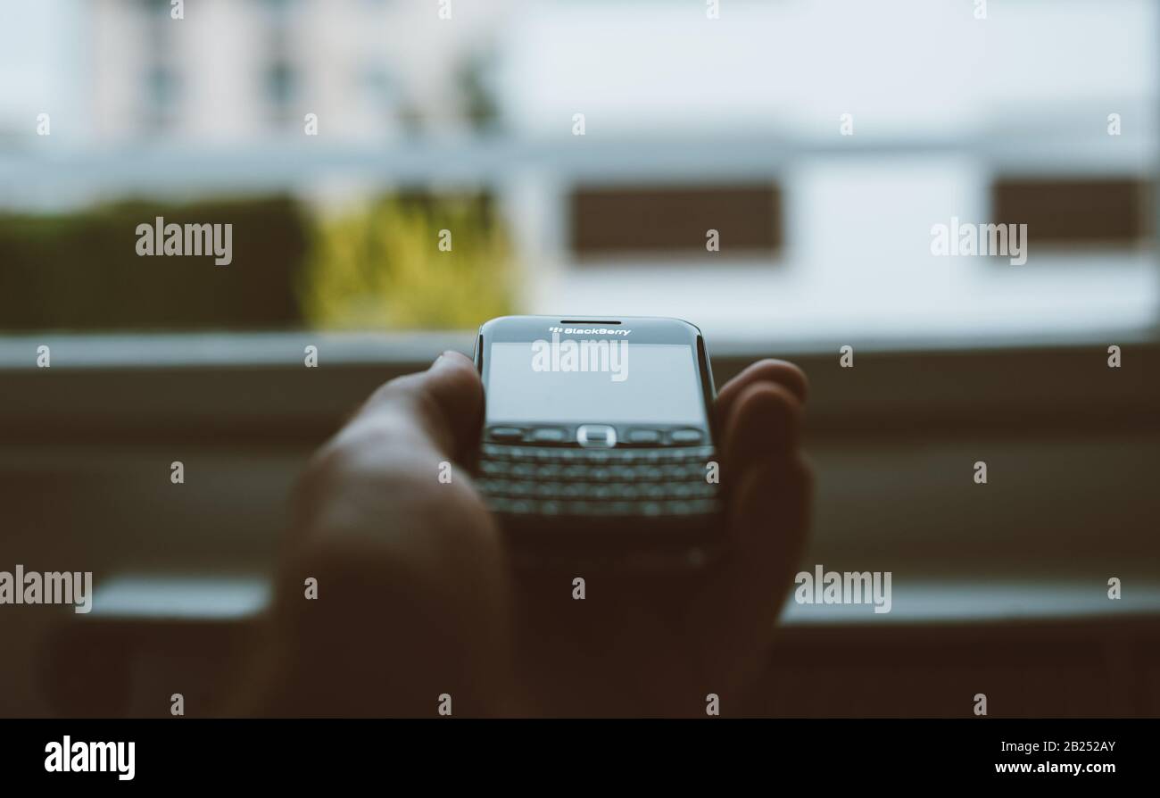 London, United Kingdom - Apr 21, 2013: Vintage film over POV male hand  holding in palm vintage Blackberry professional smartphone with focus on  the logotype with the tilt-shift lens and large window, image size:1300x894