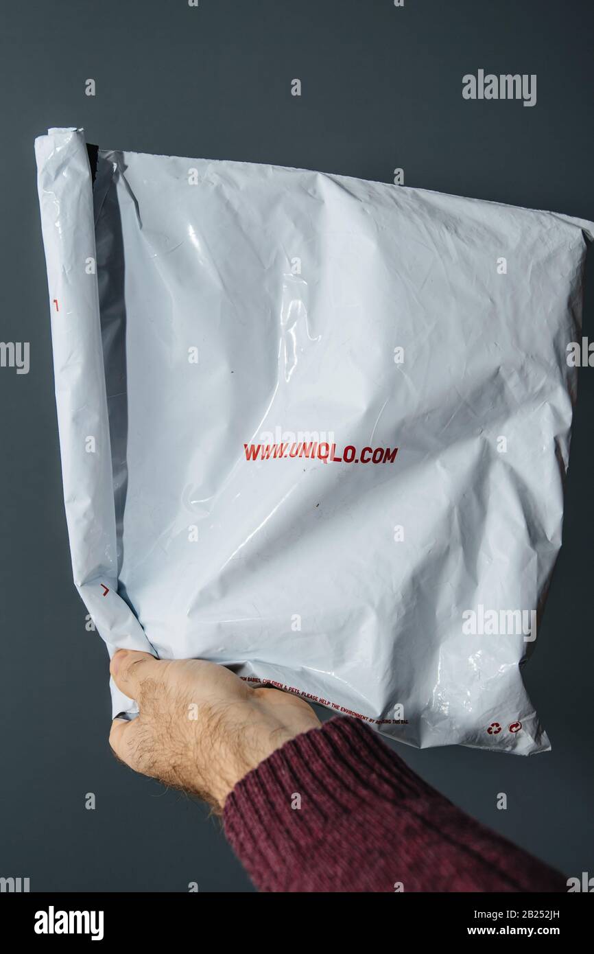 Paris, France - Feb, 24 2020: Male hand holding parcel plastic bag from  Uniqlo Japanese fashion retailer - gray background Stock Photo - Alamy