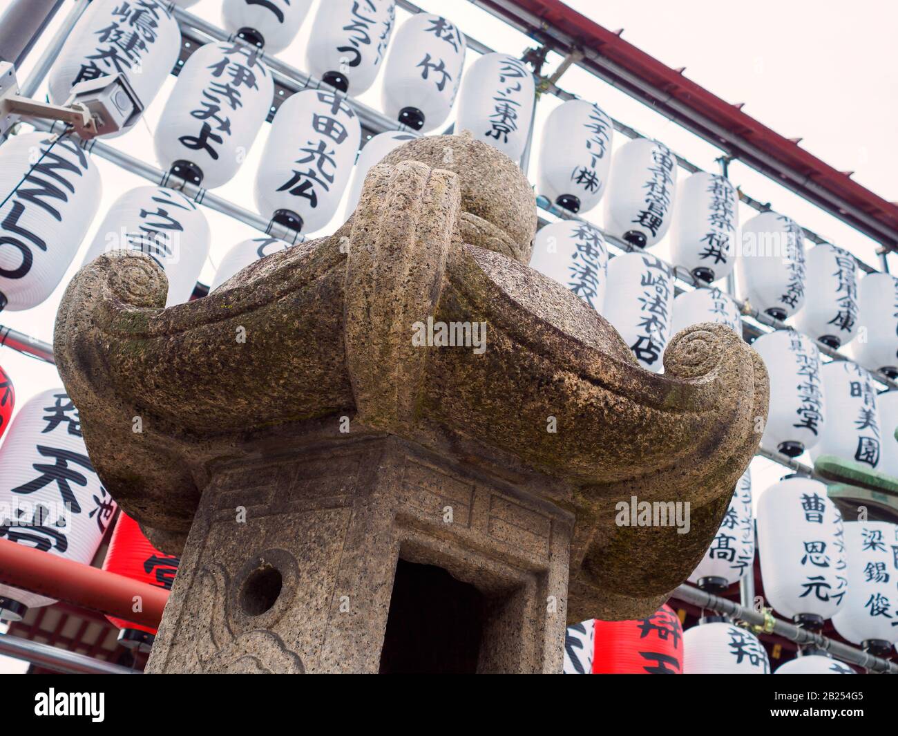 Stone lantern and paper lanterns outside a temple in Tokyo, Japan. Stock Photo
