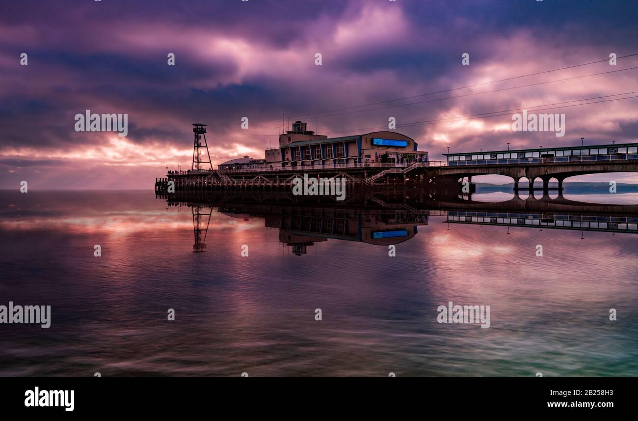 Colourful skies over Bournemouth Pier are reflected in the water Stock Photo