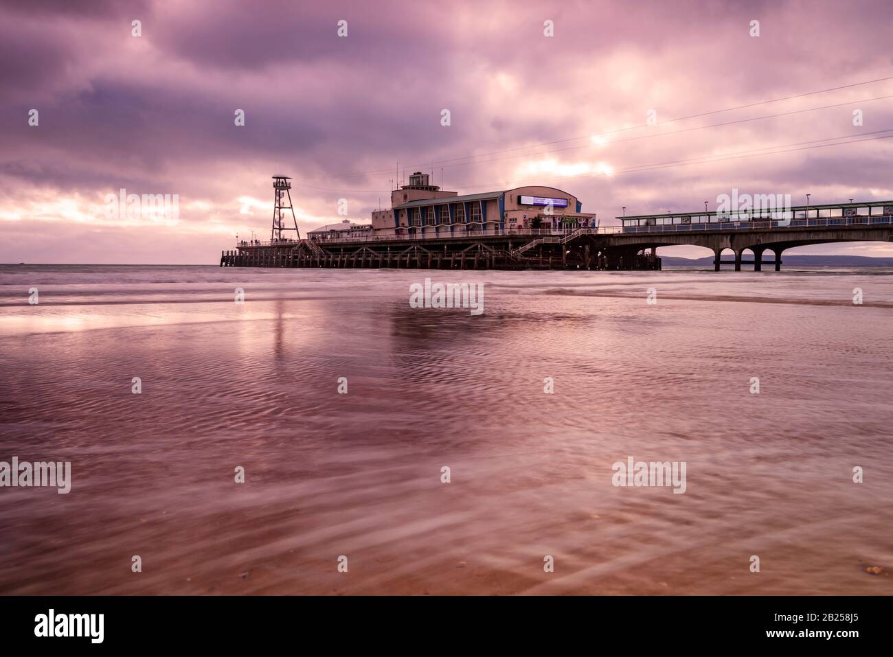 Colourful skies over Bournemouth Pier are reflected in the water Stock Photo