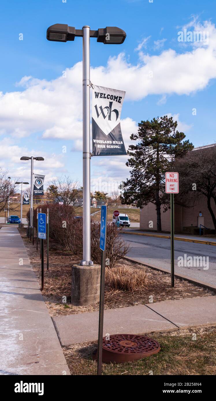 Woodland Hills High School signs displayed in the parking lot with other parking signs on a