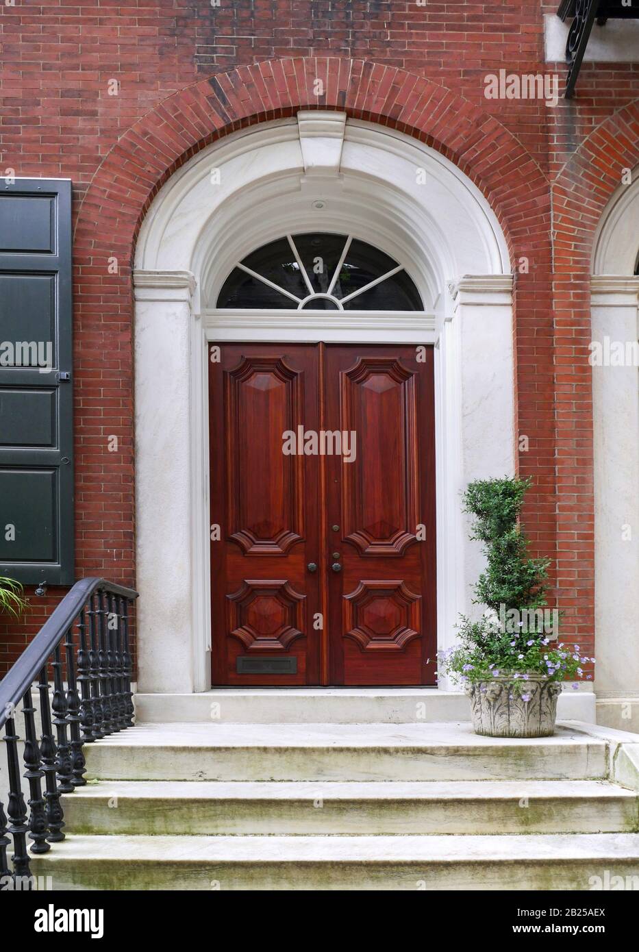 elegant wooden front door of old townhouse or apartment building Stock Photo