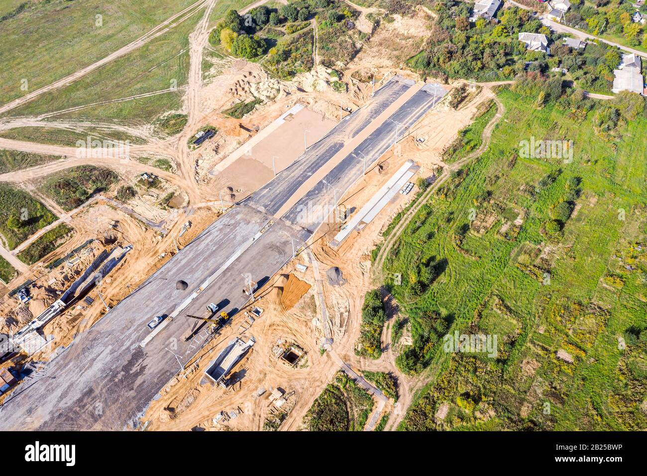 building of new city road in suburb area. heavy industrial machines working at construction site. aerial view Stock Photo