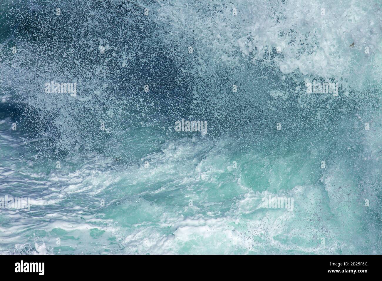 Aquatic background of sea surf waves splashing close up with clear blue green water and white foam Stock Photo