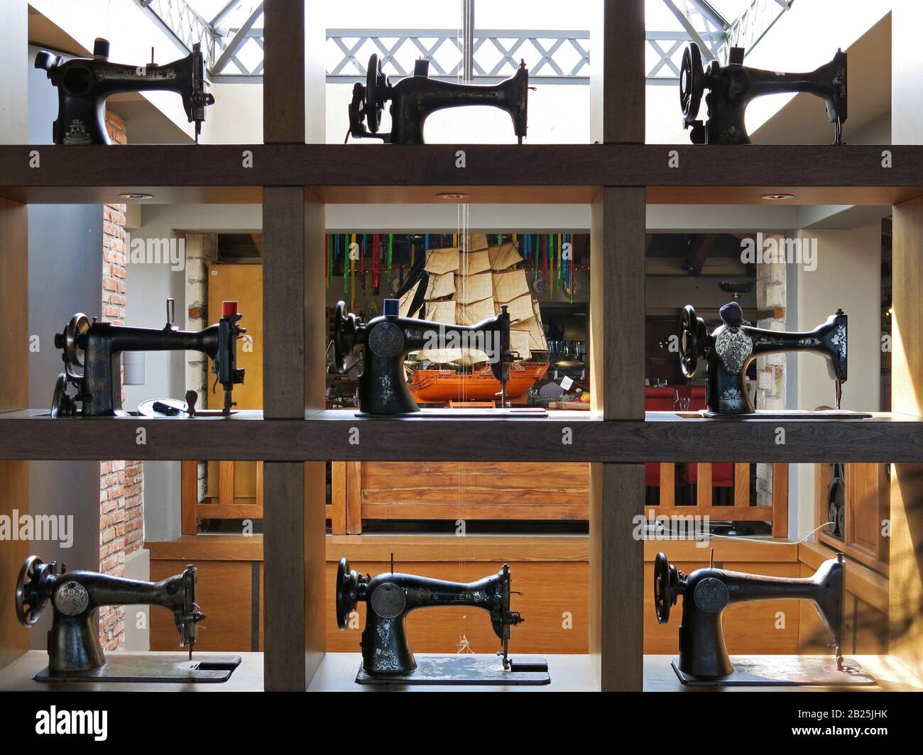 Selection of vintage sewing machines, used as decoration on a bookcase. Stock Photo