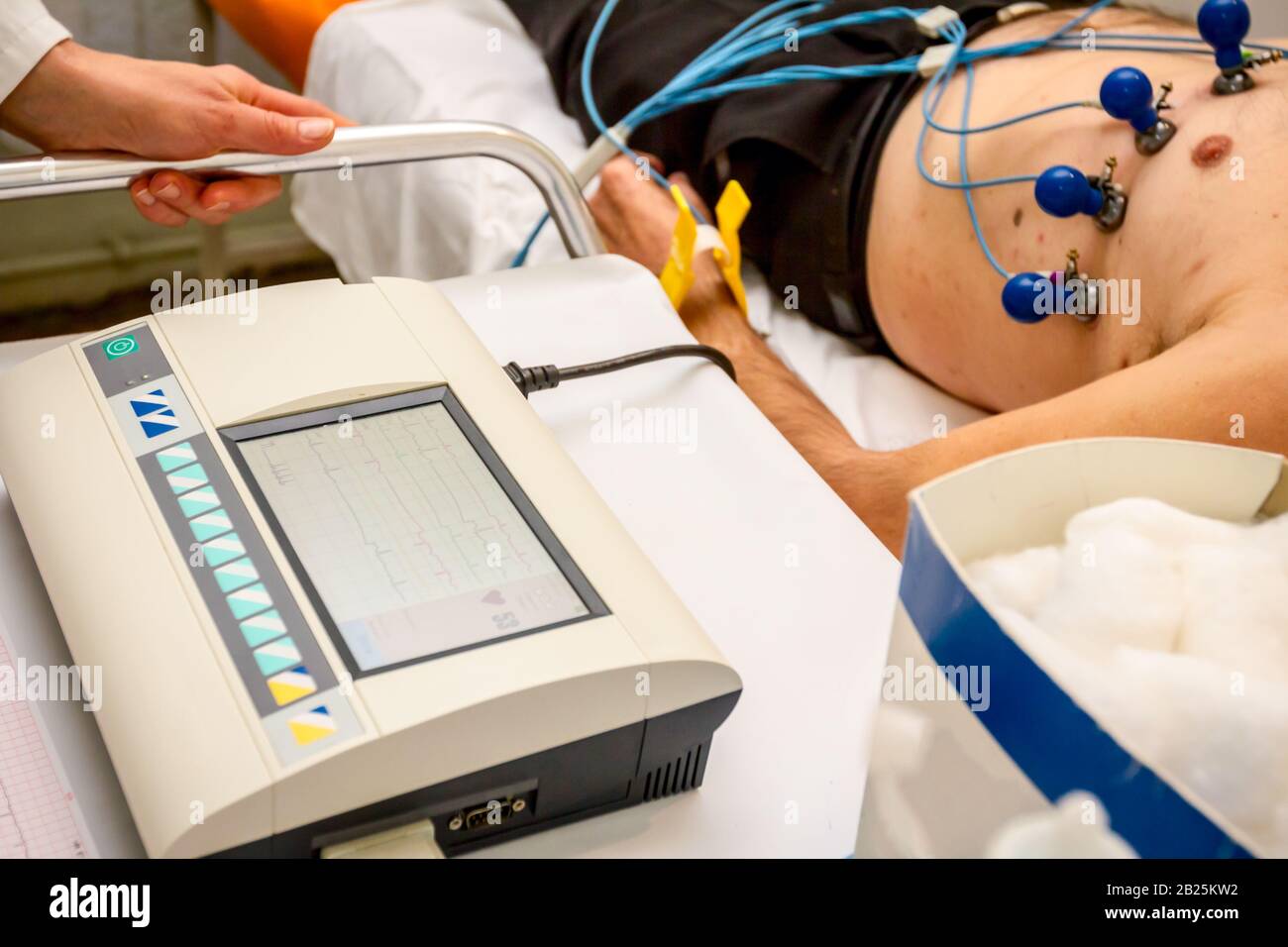 Cardiologist with electrocardiogram equipment is making cardiogram test