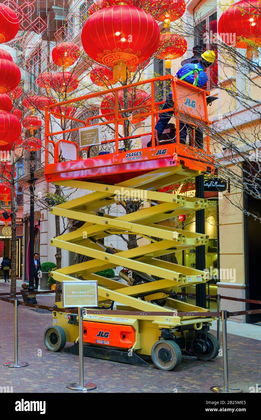 Electrician on a hydraulic scissor lift serves a street lamp. Around the  decoration of Chinese lanterns. Hong Kong, 2018-03-06 Stock Photo - Alamy