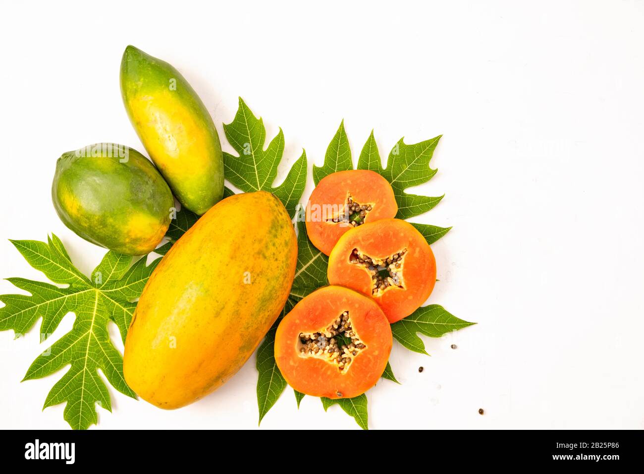 Ripe freshly cut papaya and whole fruits with green papaya leaf on white  background, isolated, flat lay, copy space Stock Photo - Alamy