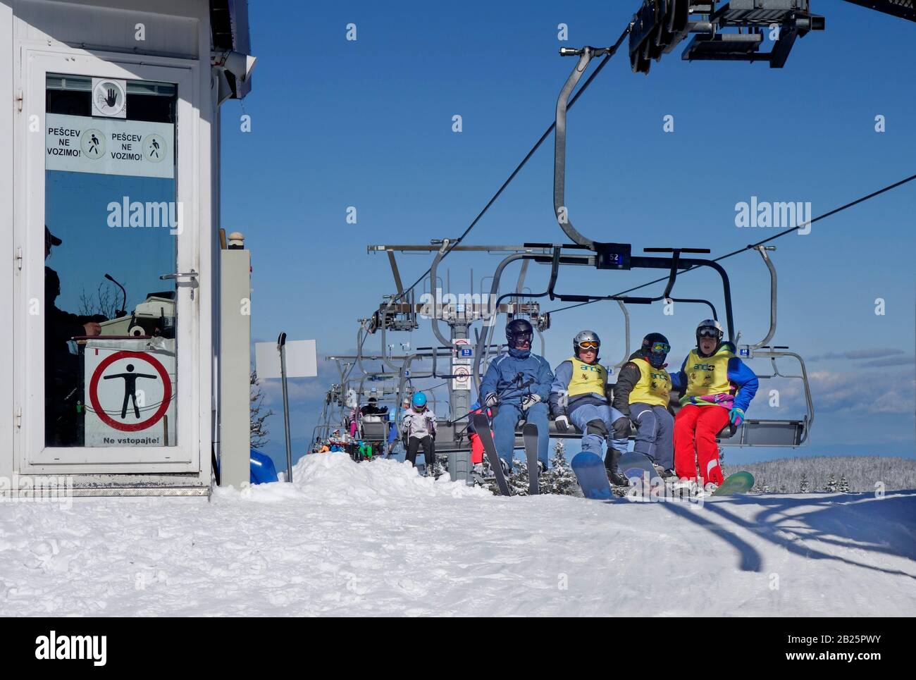 Skiers are about to get off the Ski Chairlift at Platform Station, Rogla ski resort, Slovenia Stock Photo