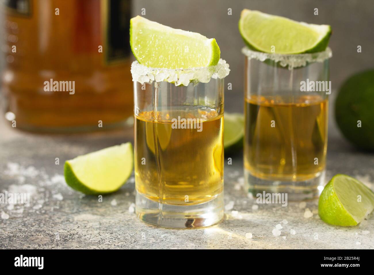 Gold Tequila. Mexican Gold Tequila shot with lime and salt on a stone