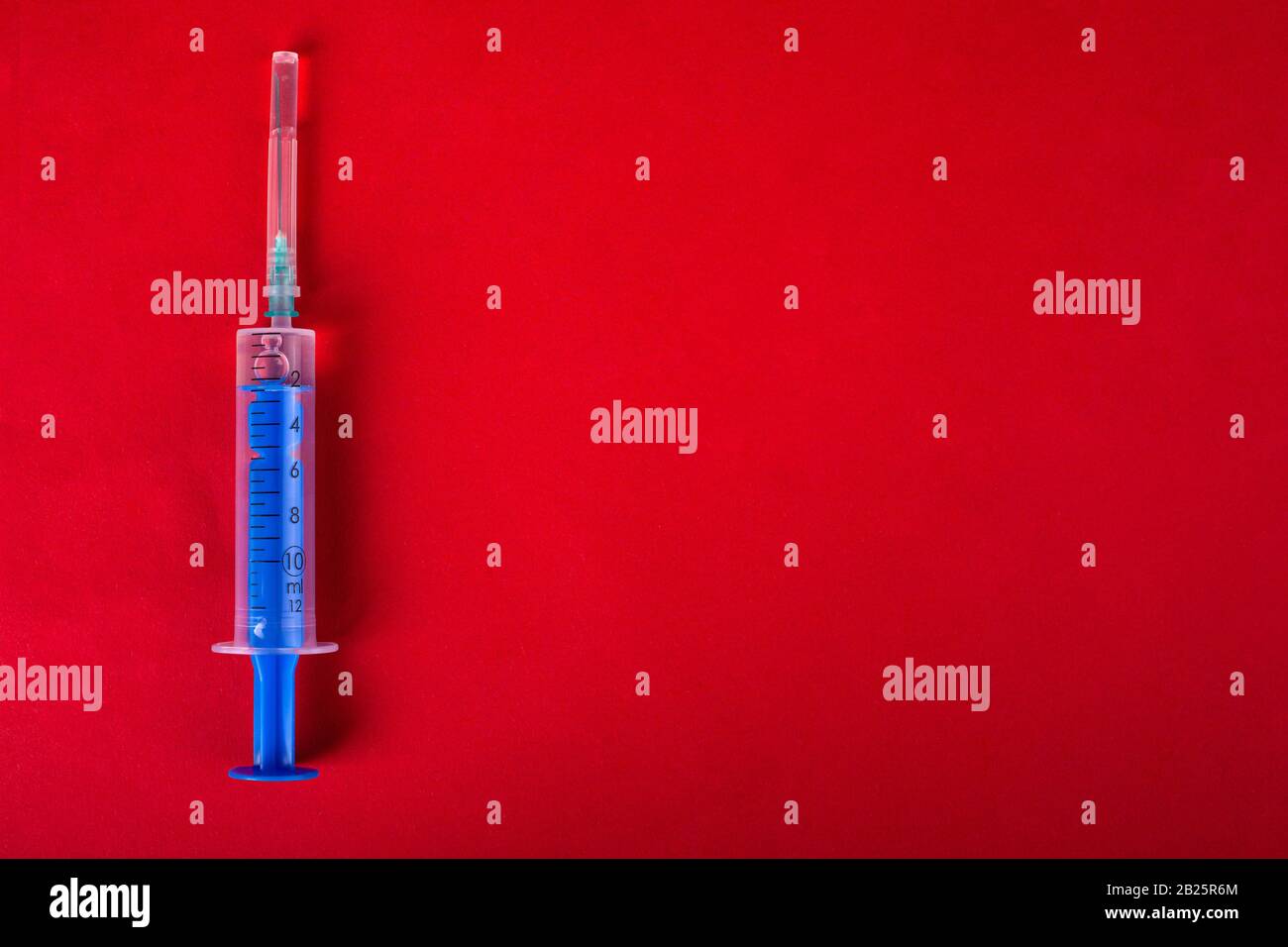medical syringe on a red background with copy space. Stock Photo
