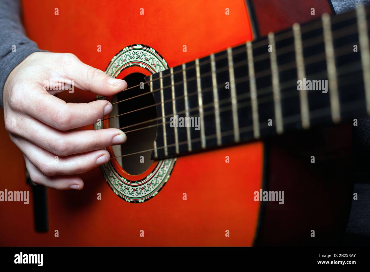 a woman learns to play a six-string classical acoustic guitar. close-up. Stock Photo