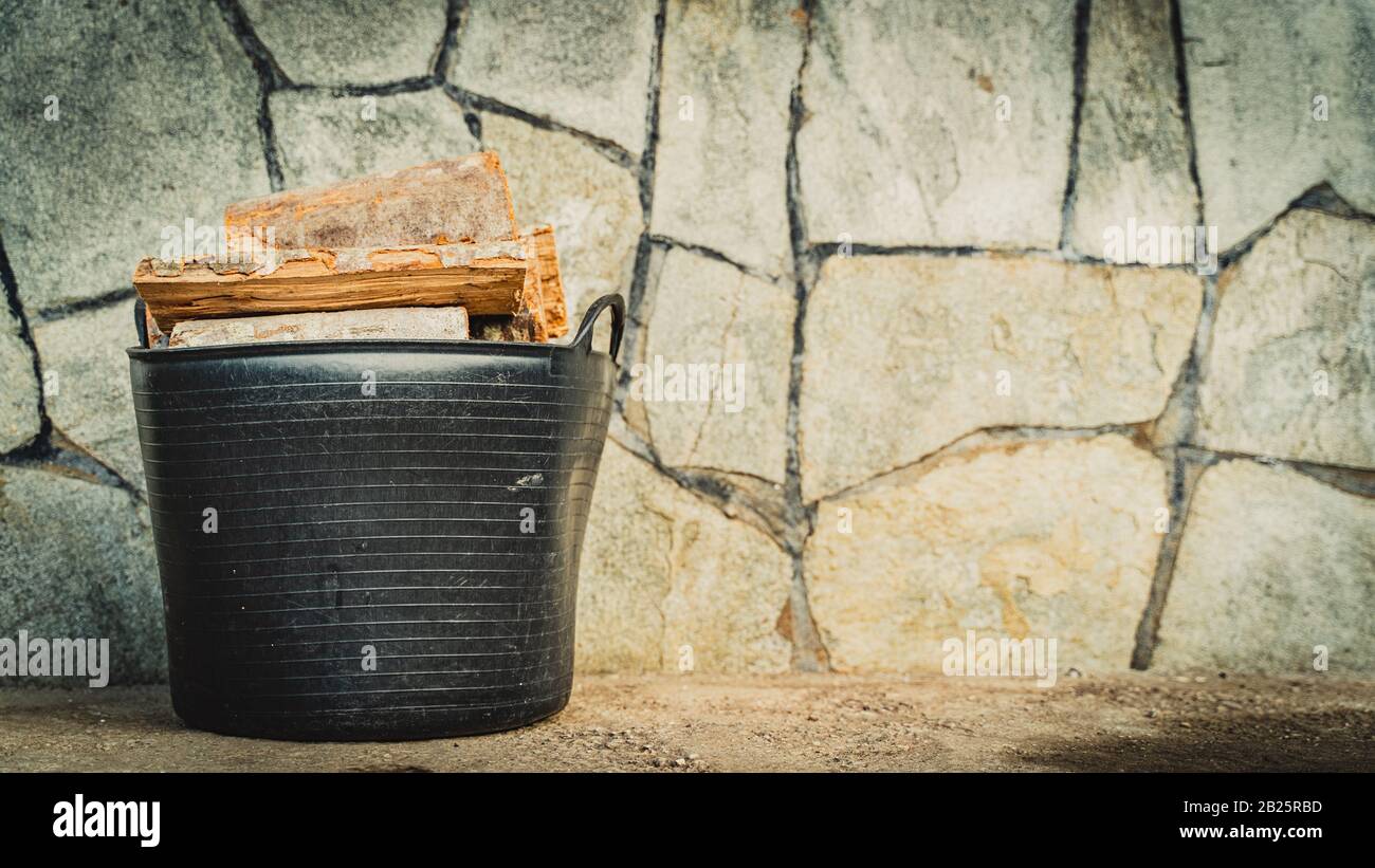 black bucket full of wooden logs Stock Photo Alamy