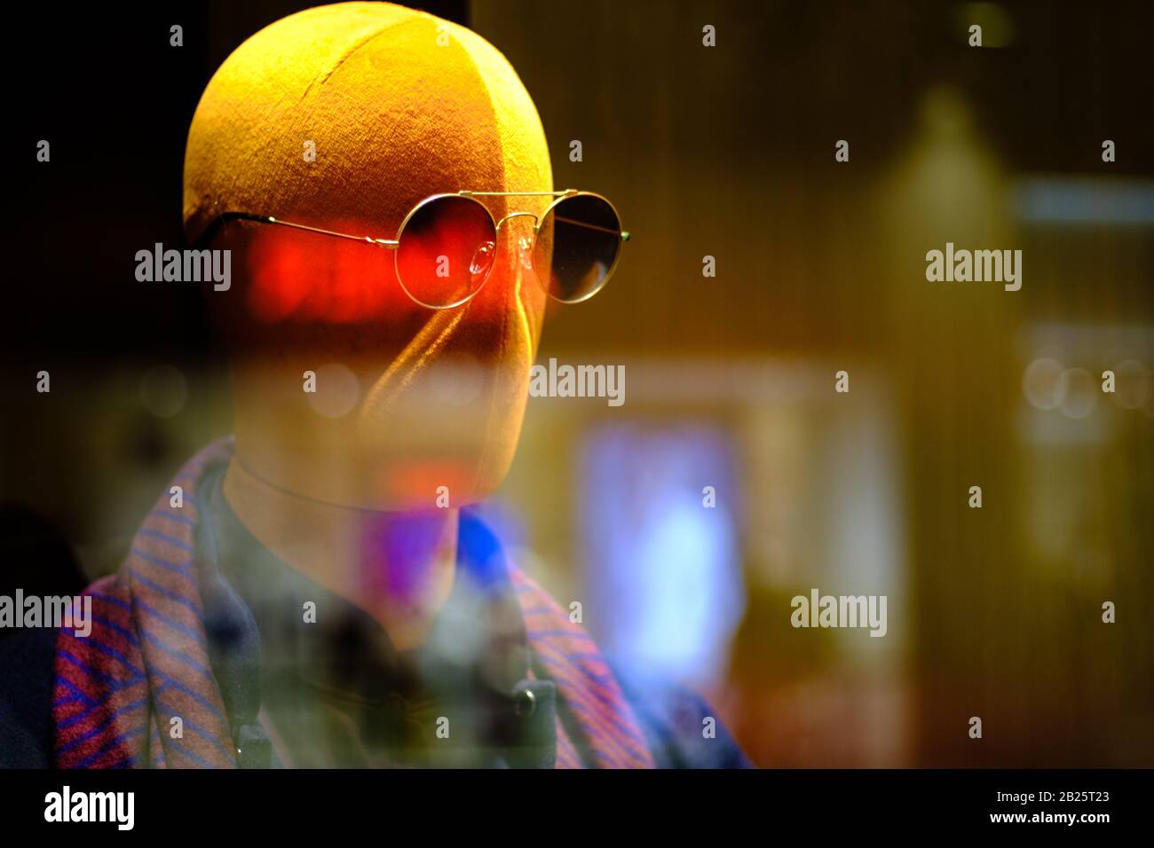 mannequins wear glasses display in window with colorful light