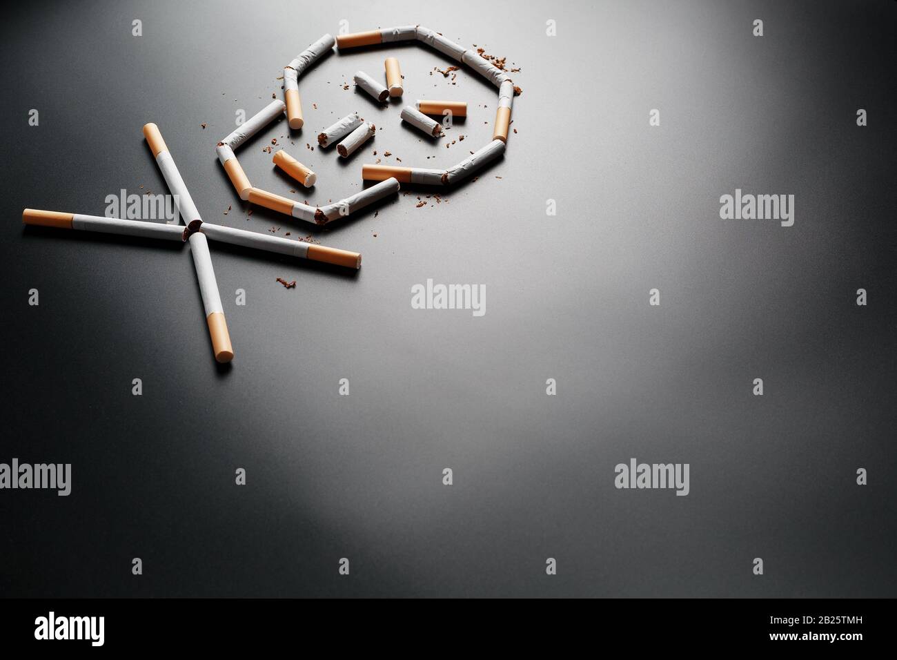 f word for cigarette Skull from cigarettes on a black background. The concept of smoking kills.  Toward the concept of smoking as a deadly habit, nicotine poisons, cancer f  Stock Photo