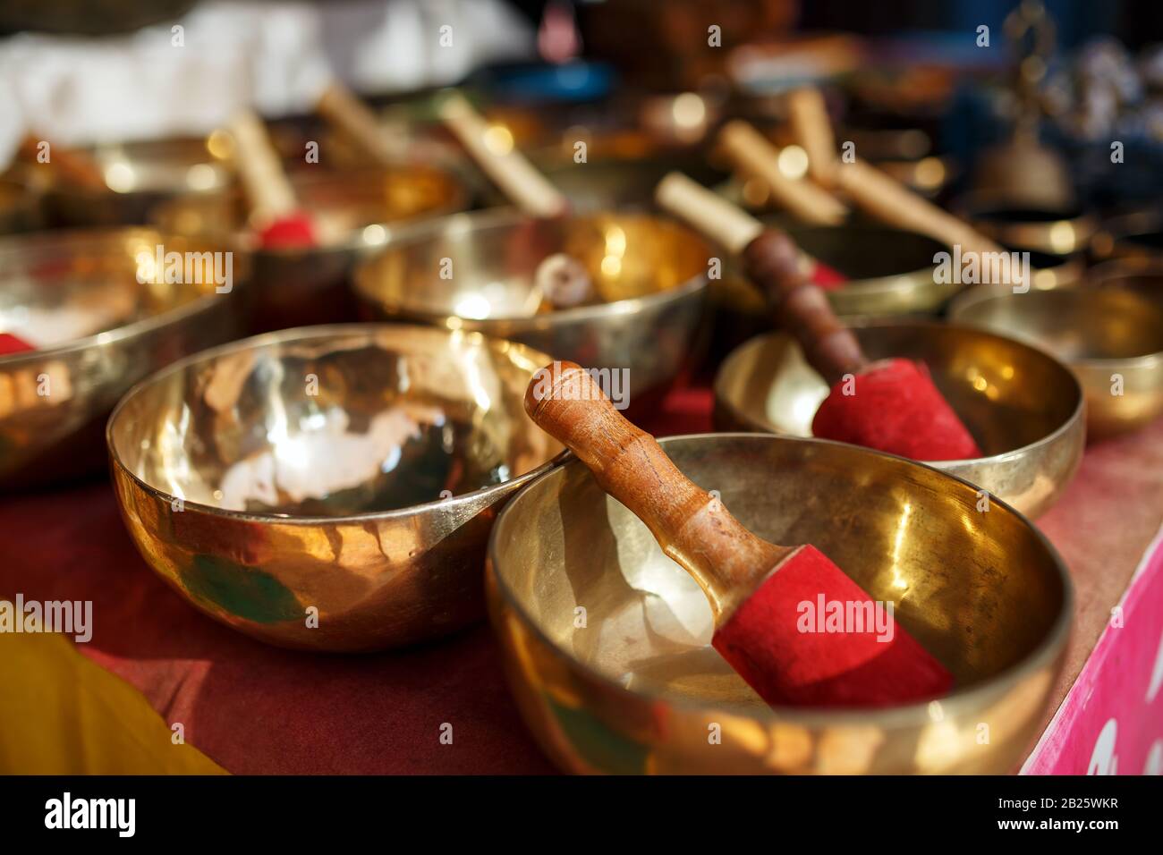 Golden Tibetan singing bowls on counters with red cloth of the night