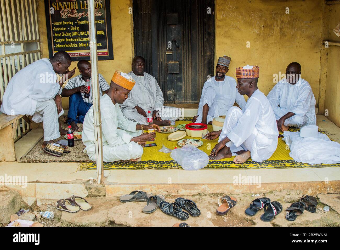 Muslim men share a meal as they celebrate eid on a street in Nigeria. Stock Photo