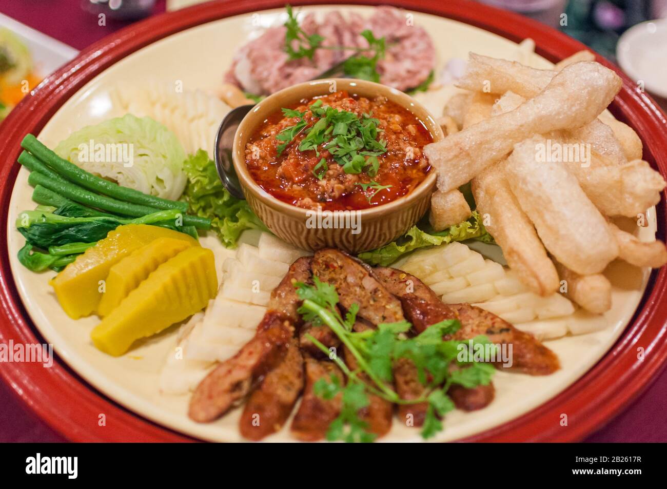 plate with the traditional Northern Thai food dish Nam Prik, steamed Vegetables and Sai Oua sausage in Chiang Mai Stock Photo