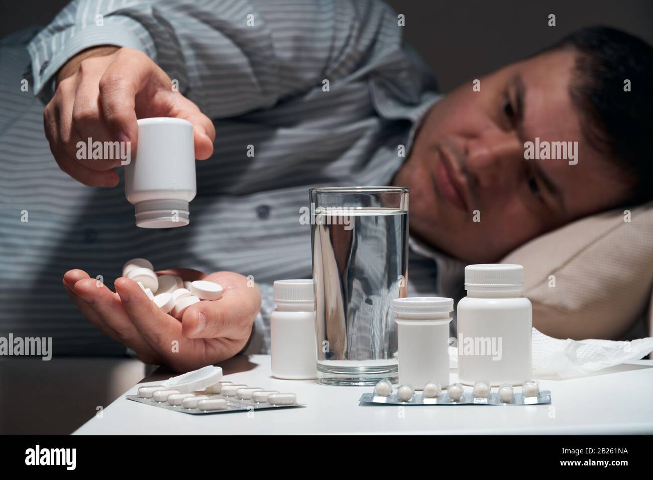 Overworked businessman is lying on the sofa and resting. Pills and