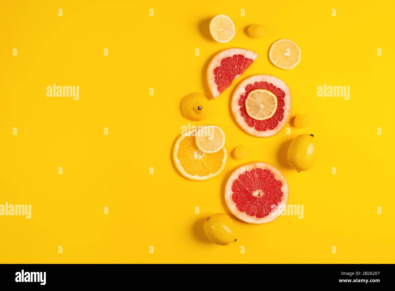 Composition of citrus fruit, orange and lemon on yellow background Stock Photo