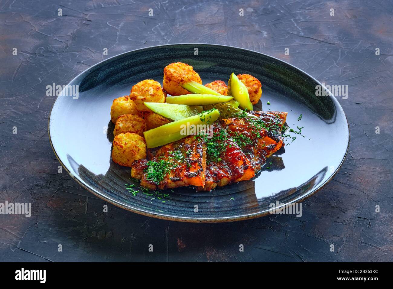 Grilled ribs with pickled cucumber and fried potato balls Stock Photo ...