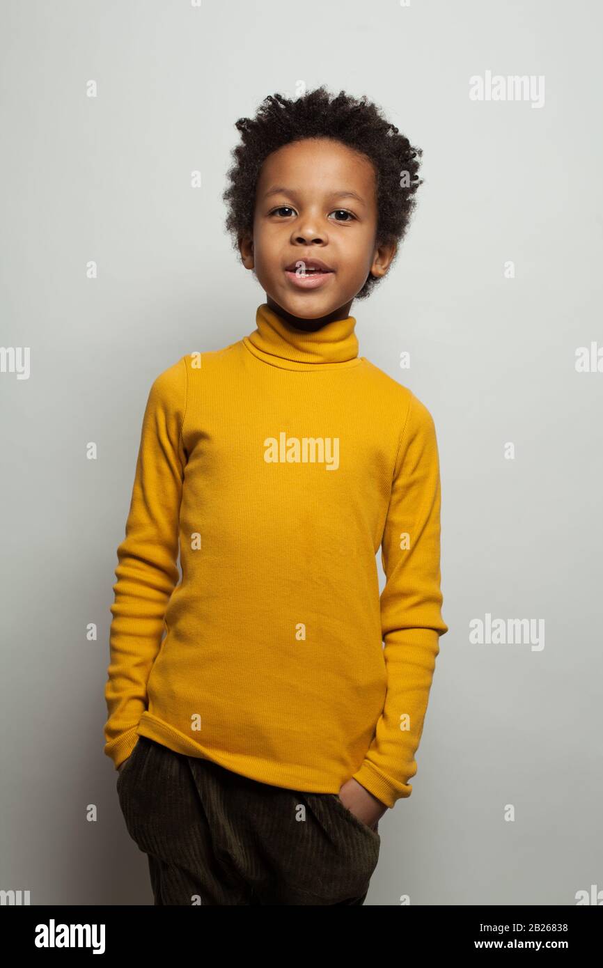 Funny African American black child boy in yellow turtleneck on white