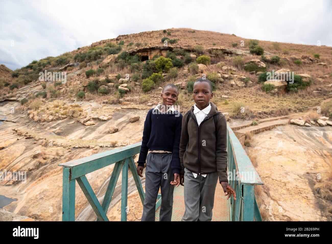 School boys crossing the Liphiring River to the Ha Baroana rock paintings, Lesotho Stock Photo