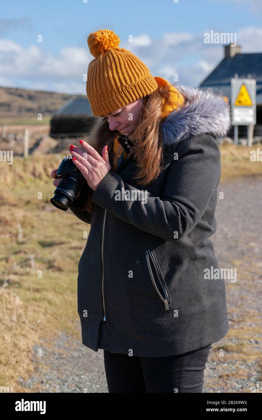 Young woman using a digital camera, Valentia Island, County Kerry, Ireland Stock Photo