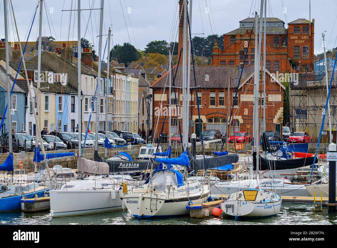 Moored yachts and boats in Weymouth Harbour with colourful houses on the Jurassic Coastline of Dorset, South West, UK Stock Photo