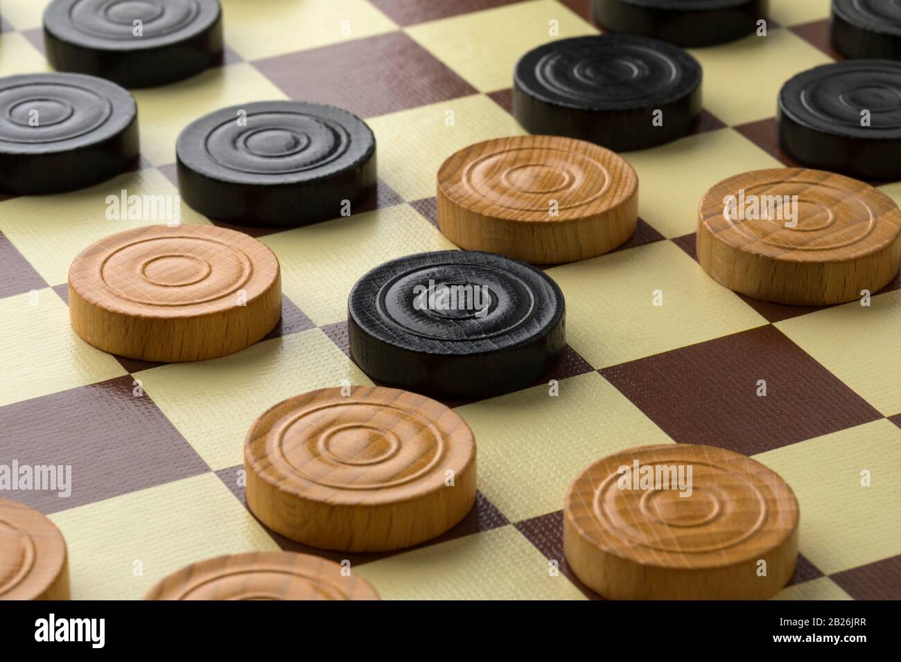 Draughts board or Checkers board with light and dark pieces close up Stock Photo