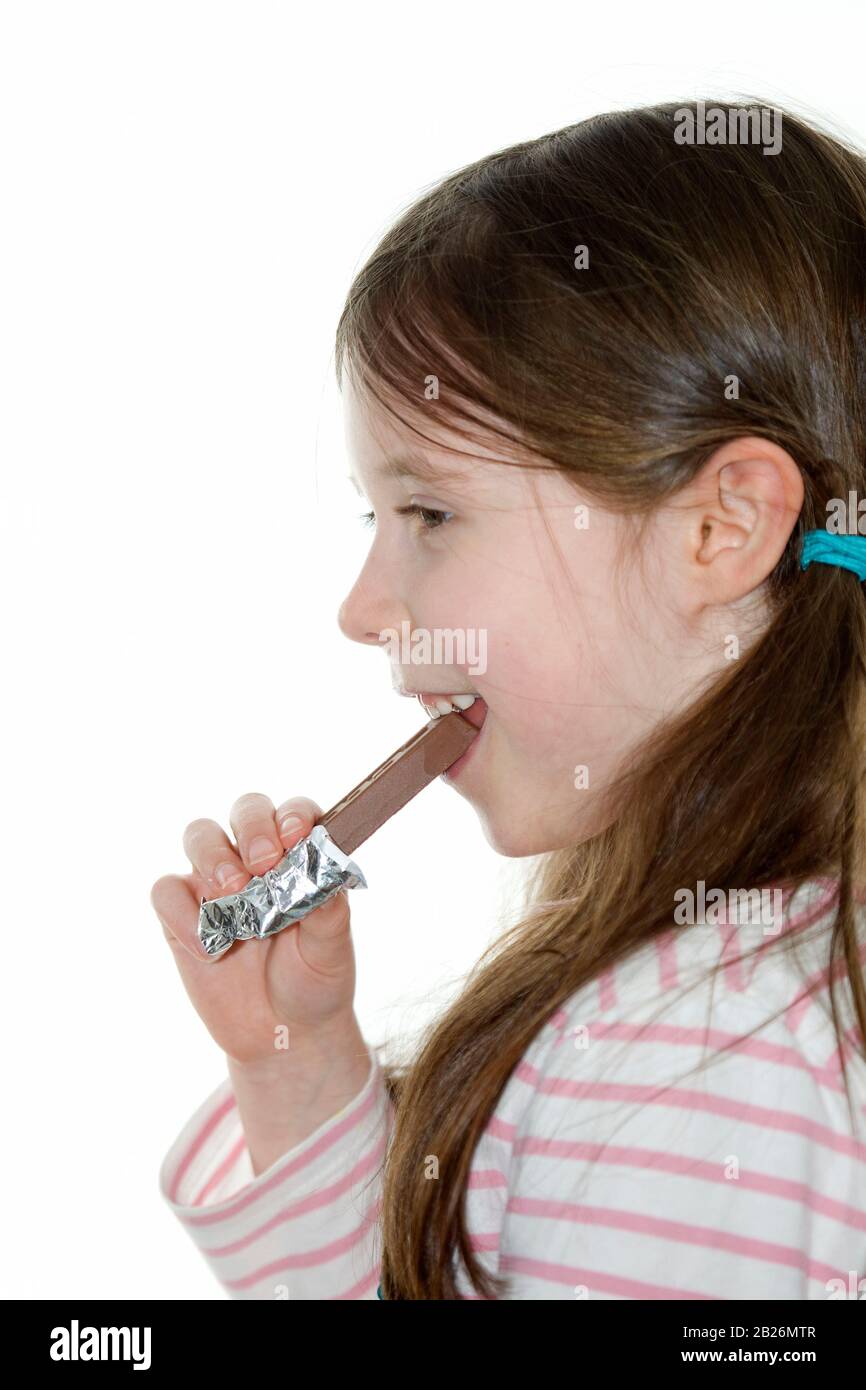 Happy girl eating chocolate bar Stock Photo