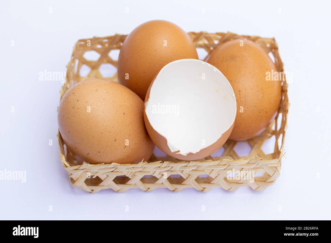 Brown chicken eggs are placed in bamboo trays. With an eggshell on a white background Stock Photo