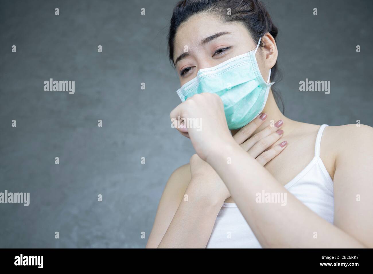 An asian woman having a cold and coughing. Girl with protective or