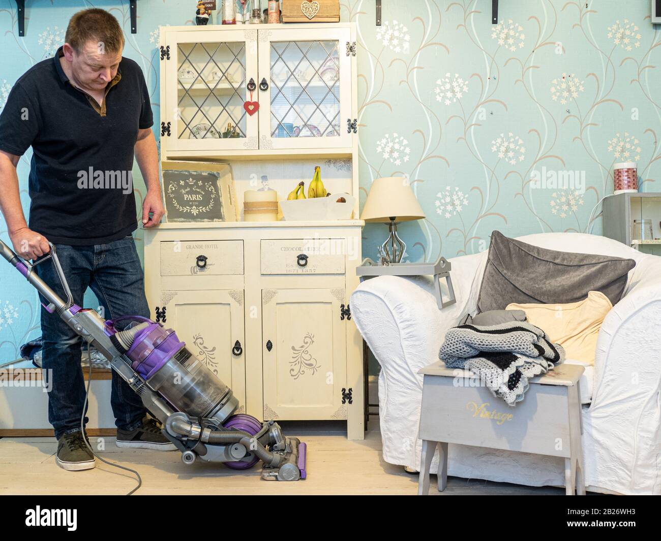Modern man vacuuming floors Stock Photo