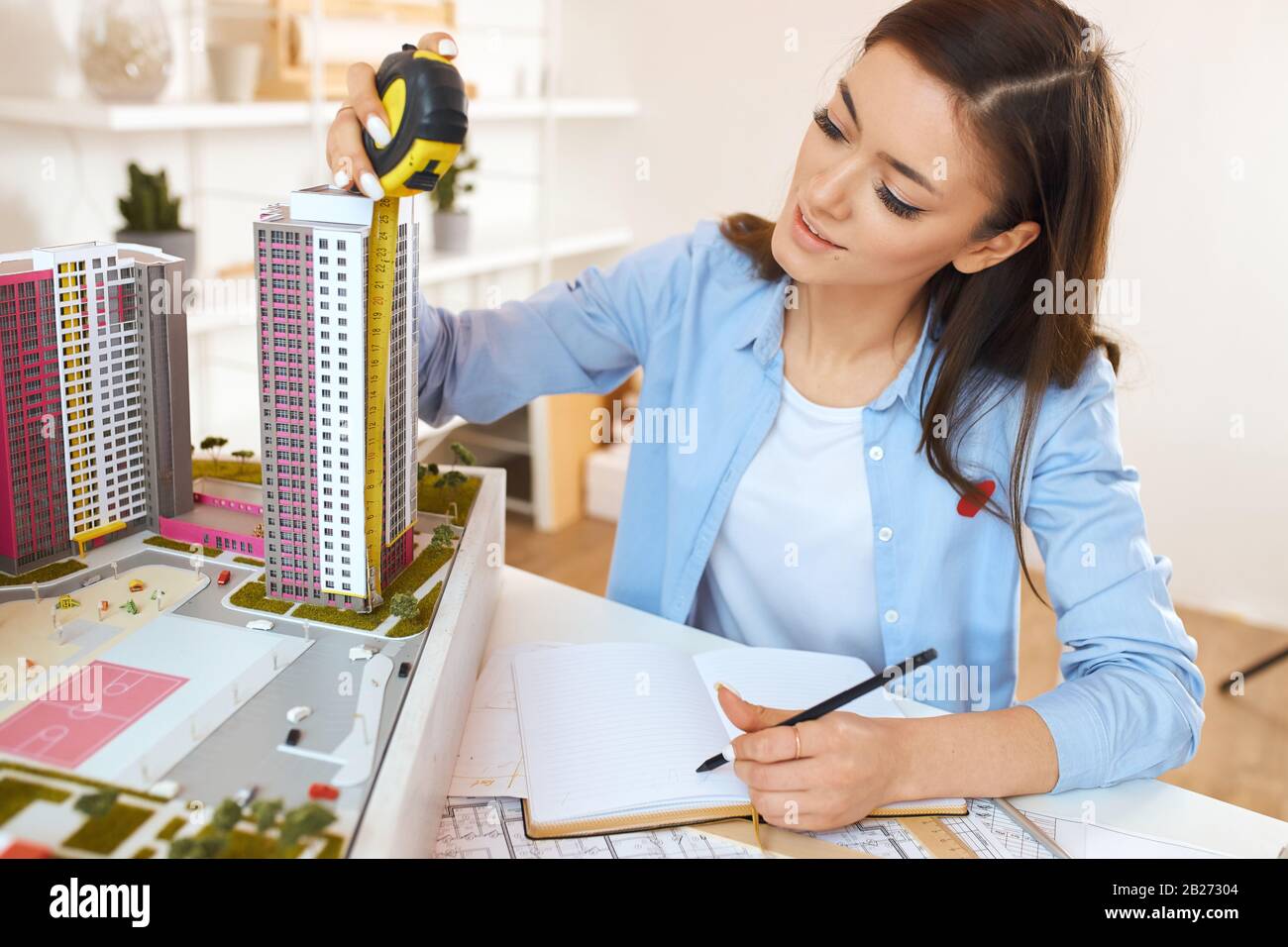 young talented architect performing construction drawings in the office room with modern interior. close up photo. horizontal shot. Stock Photo