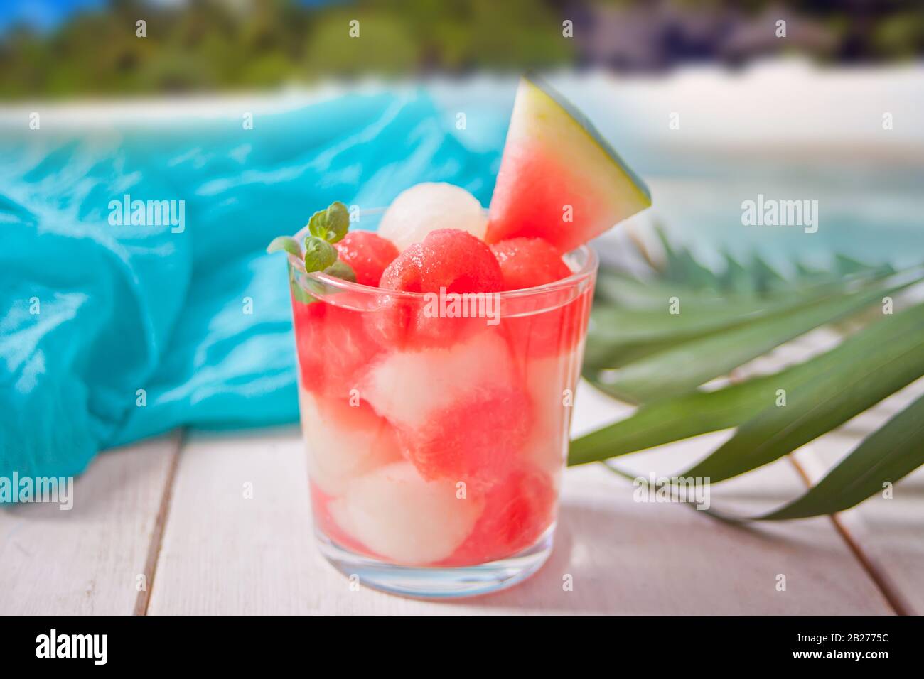 Tropical fruit salad with melon and watermelon balls in glass under the