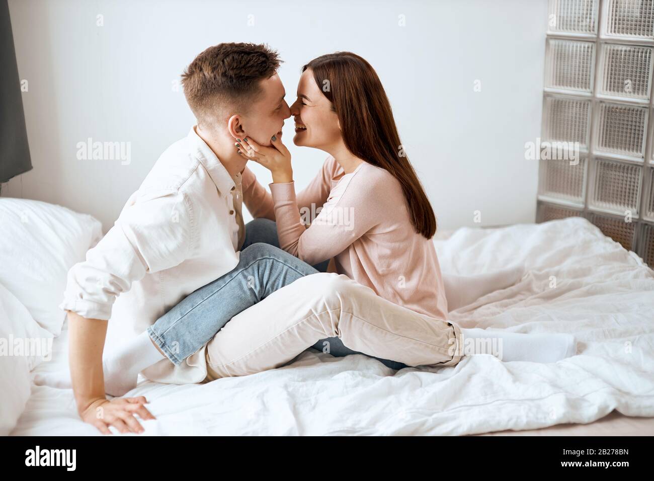 cheerful happy man and woman in cozy clothes kissing in bed. Celebrating  Christmas, Valentine, love, romance concept.side view photo Stock Photo -  Alamy