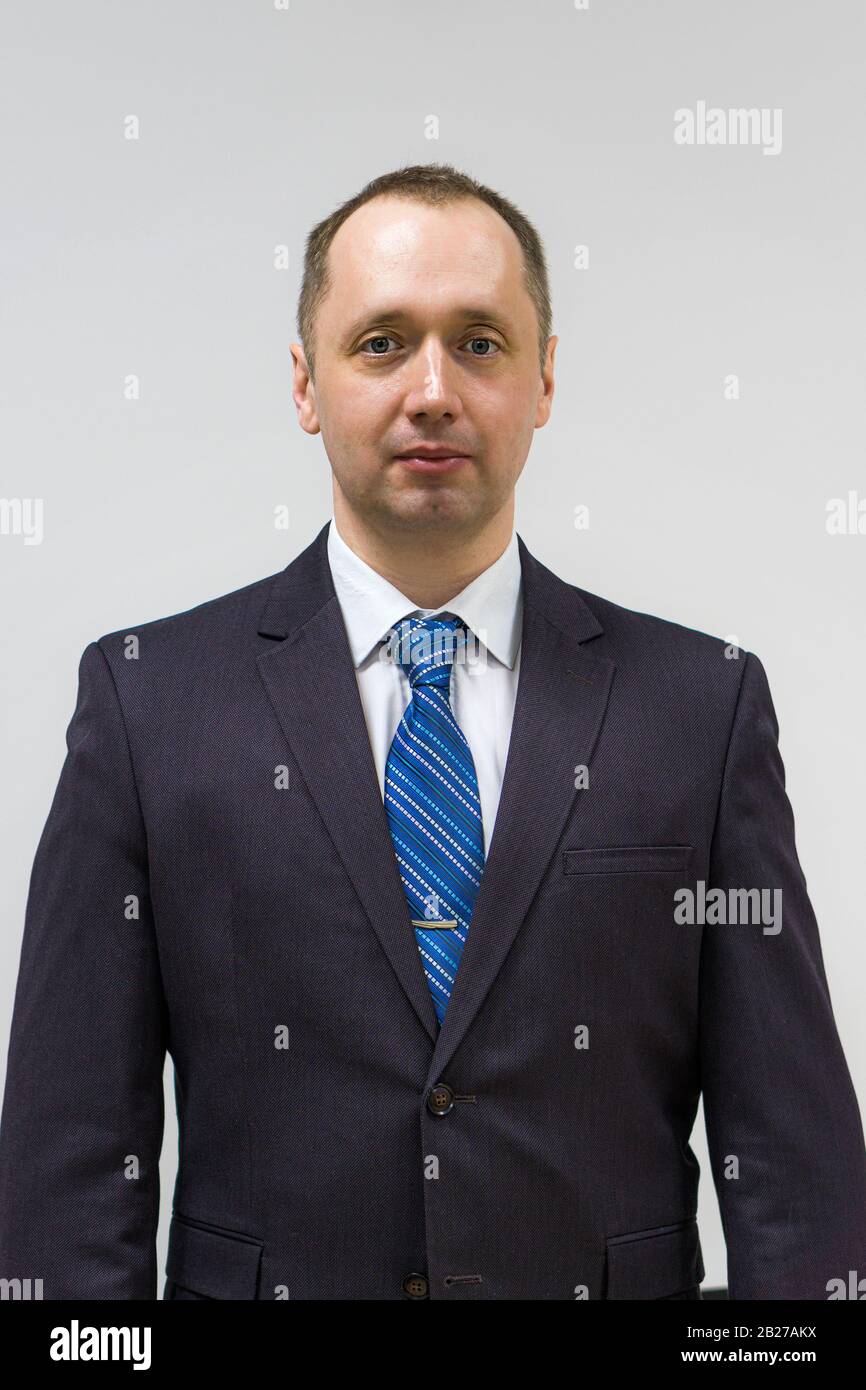 portrait of a confident, purposeful, successful businessman weared in grey suit and blue neck tie Stock Photo