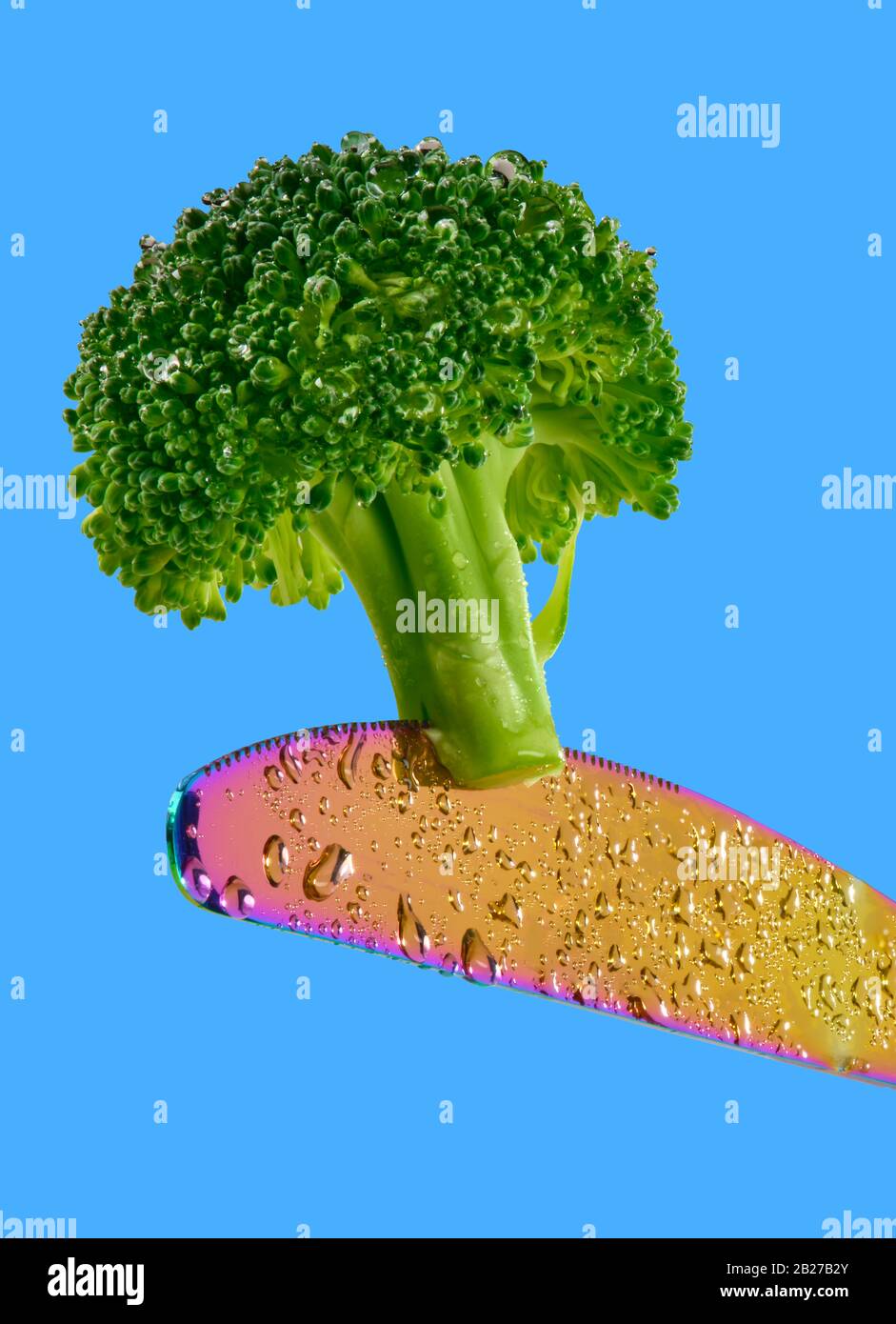 Broccoli on edge of colorful knife Stock Photo