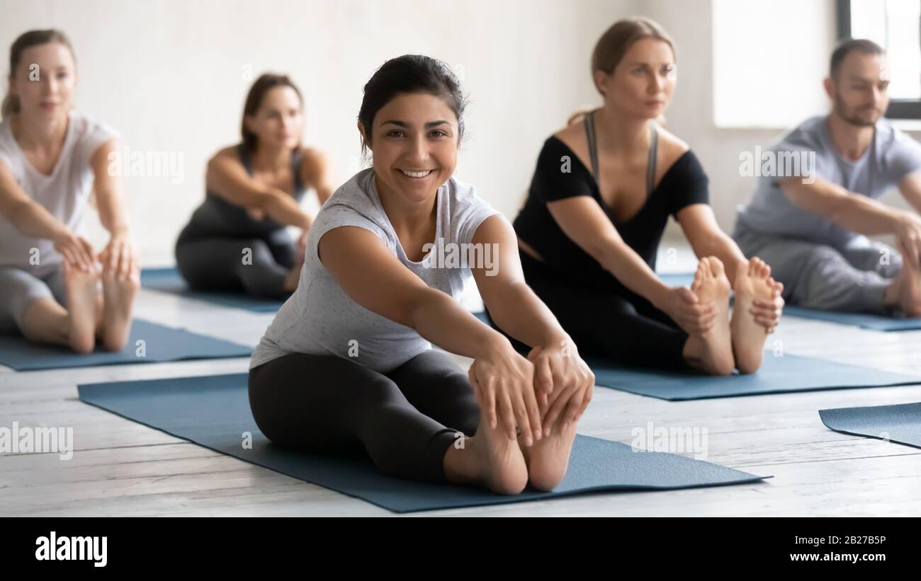 During yoga class group of people doing Seated Forward Bend Stock Photo