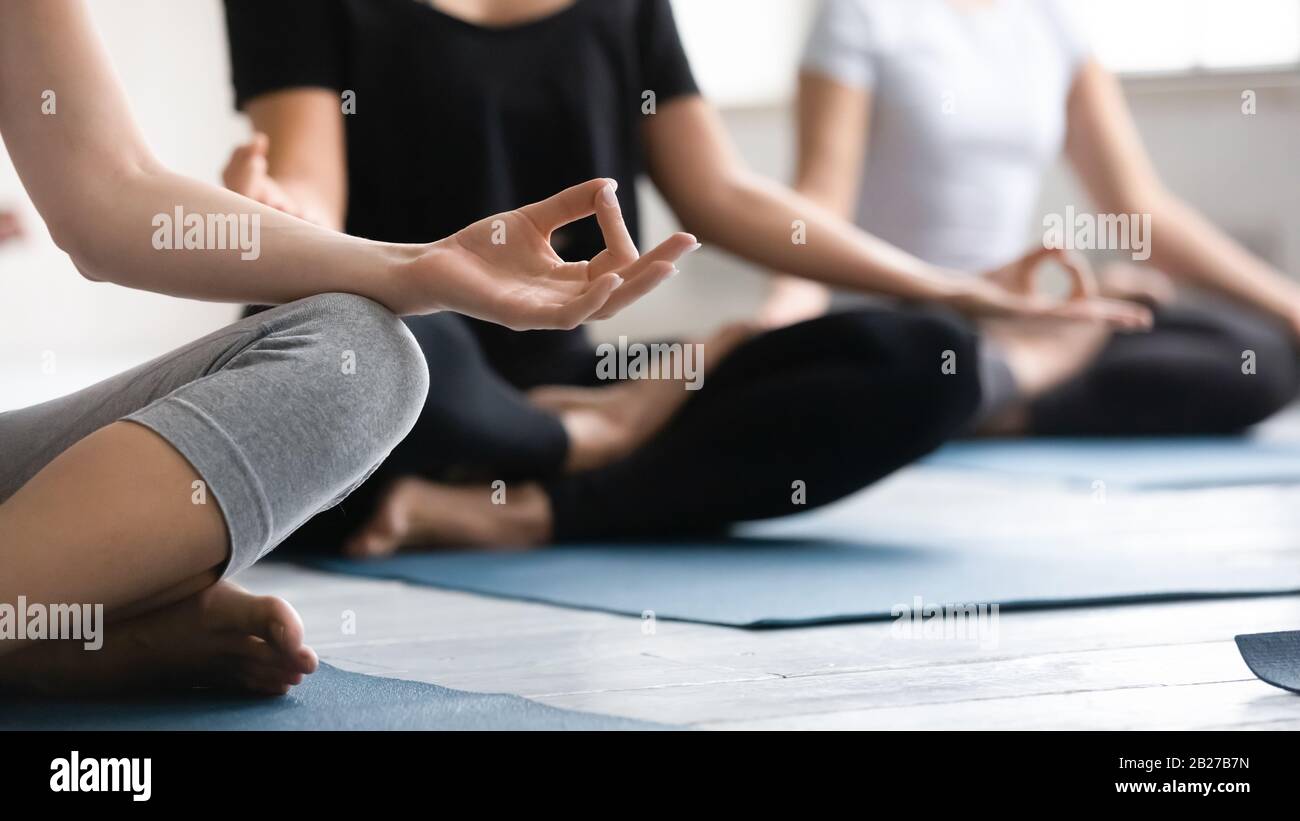 Focus on woman fingers folded in mudra gesture during meditation Stock Photo