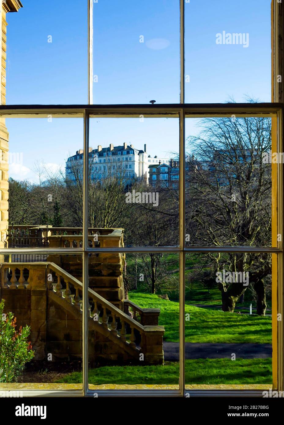 View from Scarborough Art Gallery window looking south across a wooded valley to residential and hotel buildings on the hill top Stock Photo