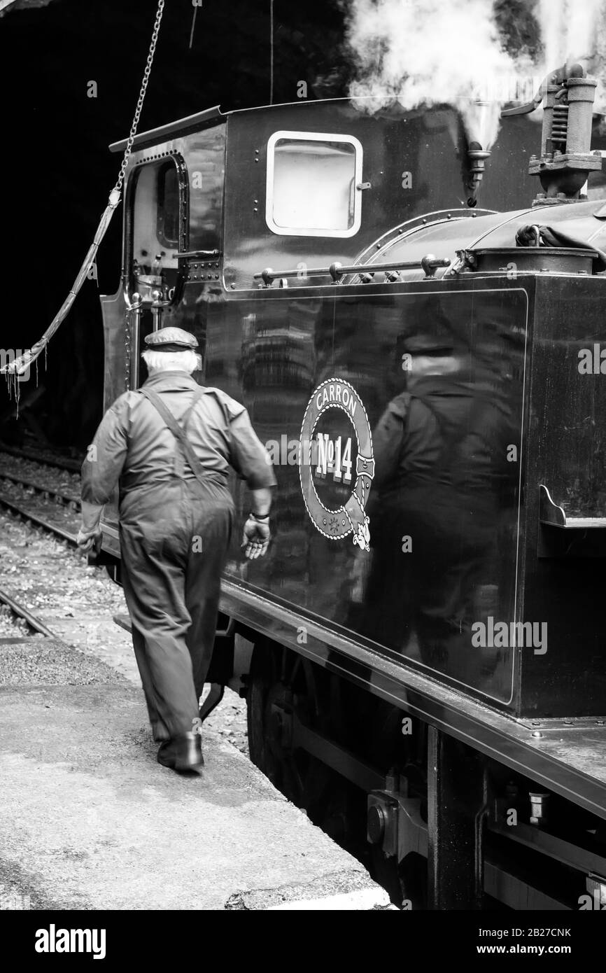 Man work in the locomotion at Haverthwaite railway station, Lake District, UK Stock Photo