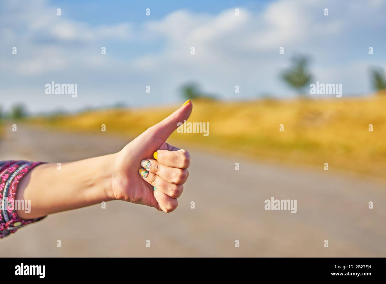 Hand of woman hitchhiker with thumbs up form the asphalt road go to journey Stock Photo Alamy