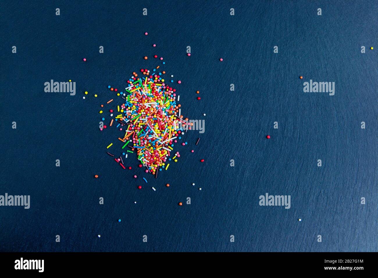 Multicolor candies on stone dark blue background. Top view with copyspace Stock Photo