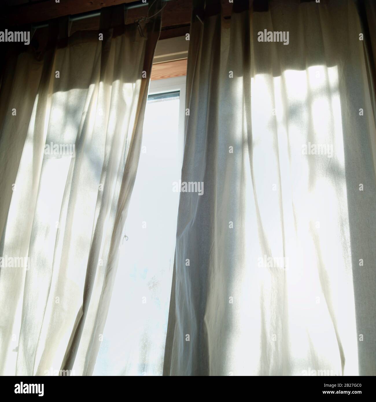 Low angle shot of a morning light through the curtains on a window ...