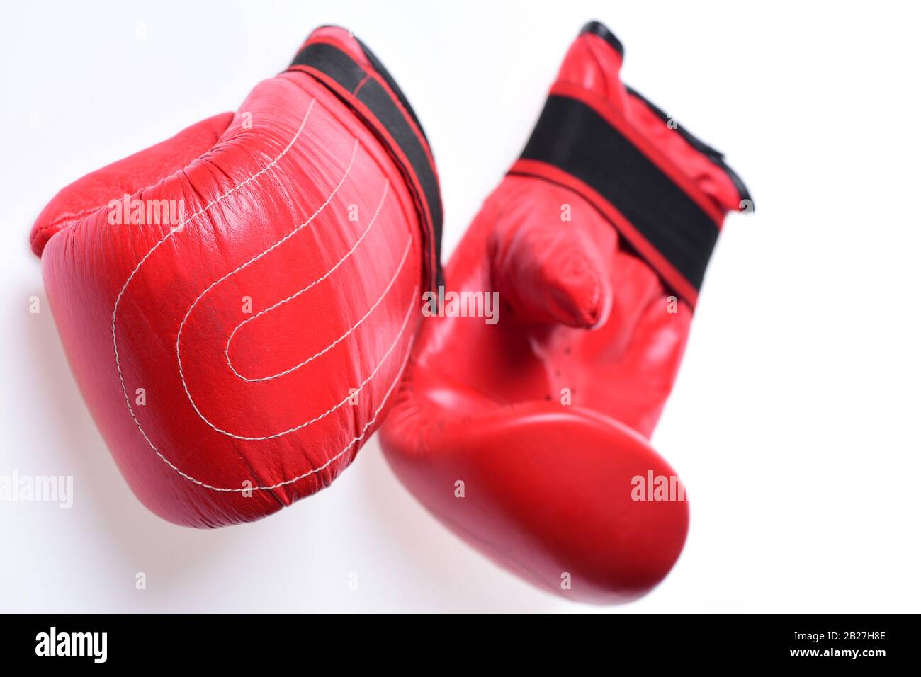 Pair of boxing gloves lying next to each other. Leather box equipment for  fight and training. Sports and martial arts concept. Boxing gloves in red  color isolated on white background Stock Photo -