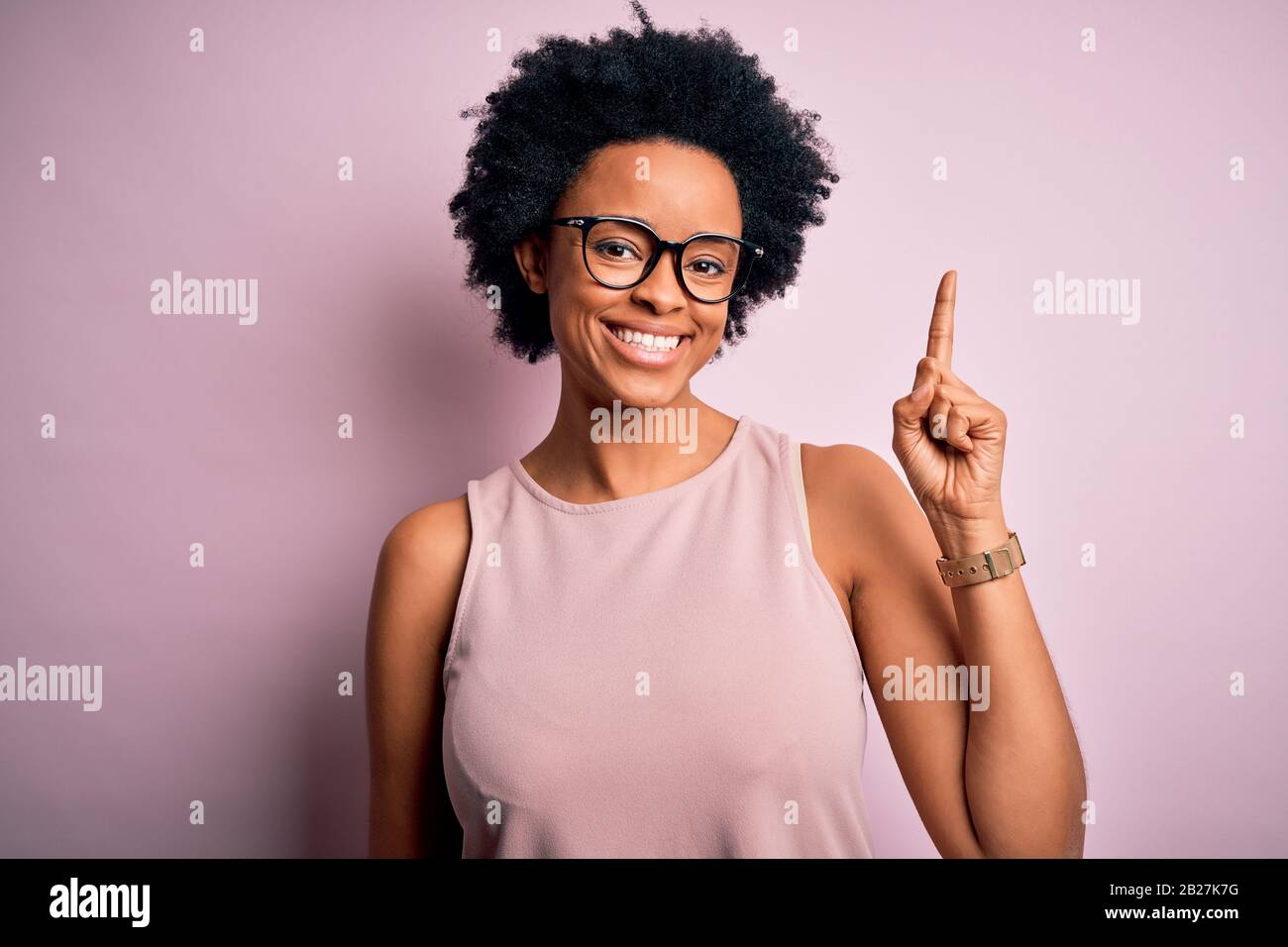 Young beautiful African American afro woman with curly hair wearing t ...